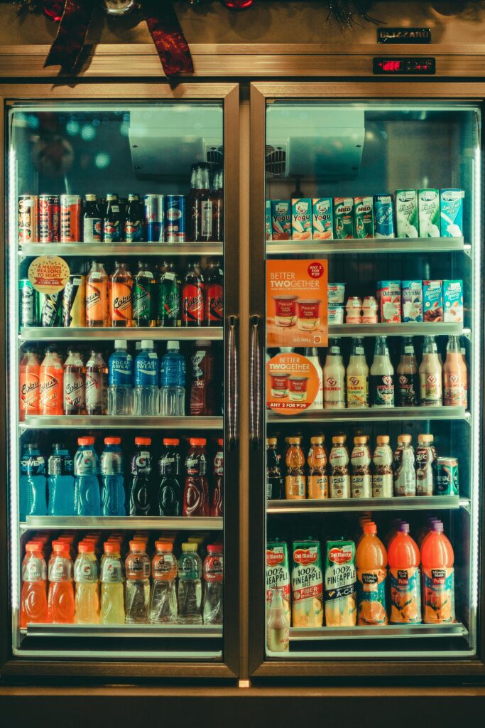 Assorted chilled beverages displayed in a store refrigerator showcasing various drink options for sale.